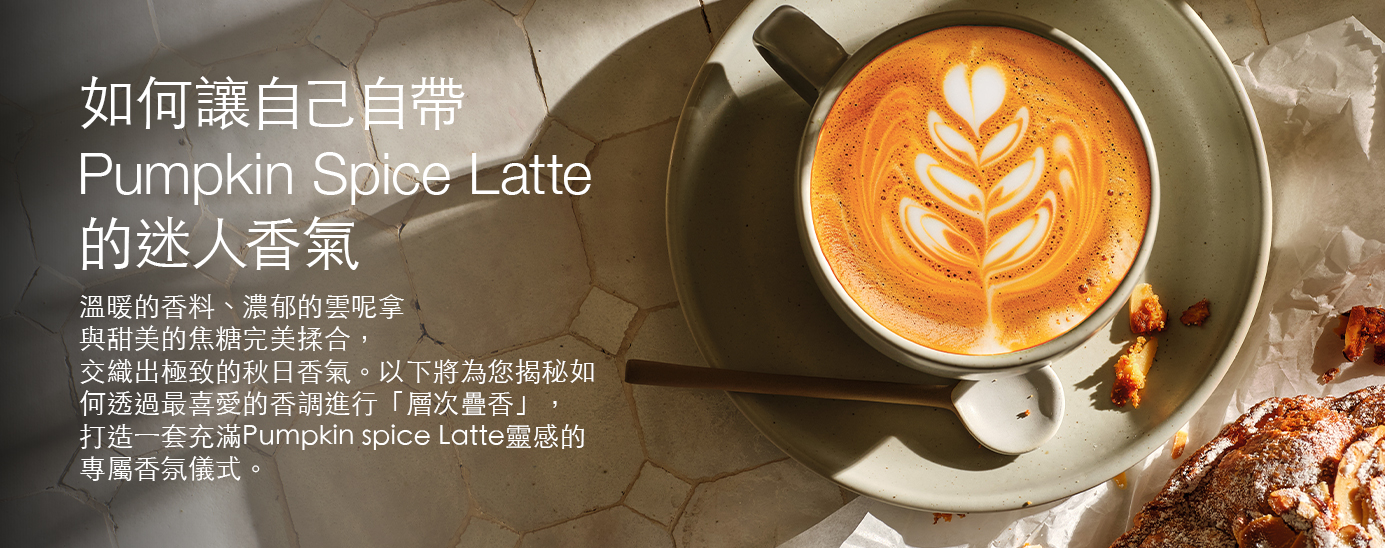 A pumpkin spice latte with latte art on a marble surface